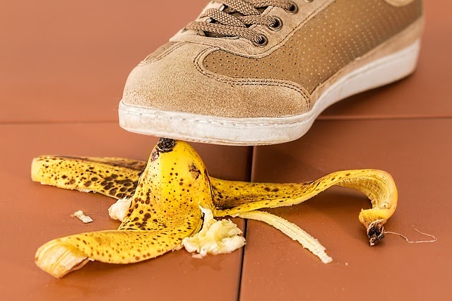 Foto di un piede che scivola su una buccia di banana